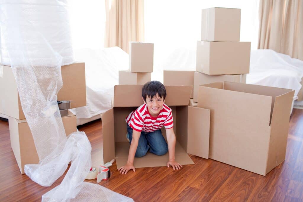 A kid is playing with boxes upon moving in.