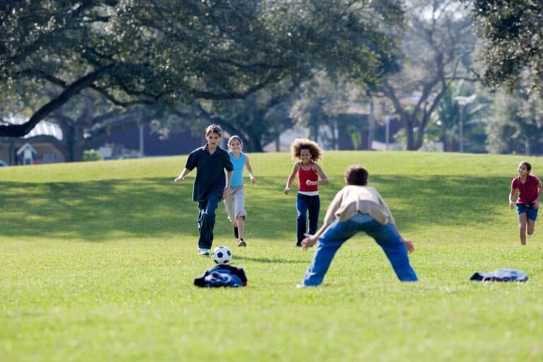 Children enjoying in a park on a sunny day in the concept of 'best parks and green spaces in Woolwich'.