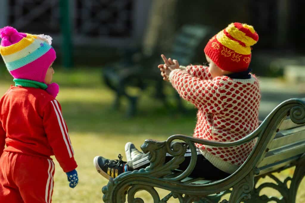 Two young kids in a park in autumn