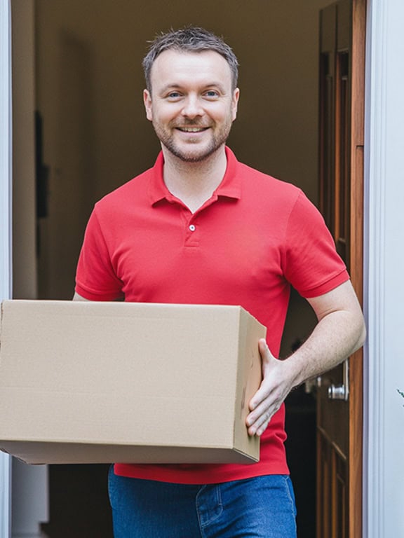 man wearing red polo shirt holding a cardboard box